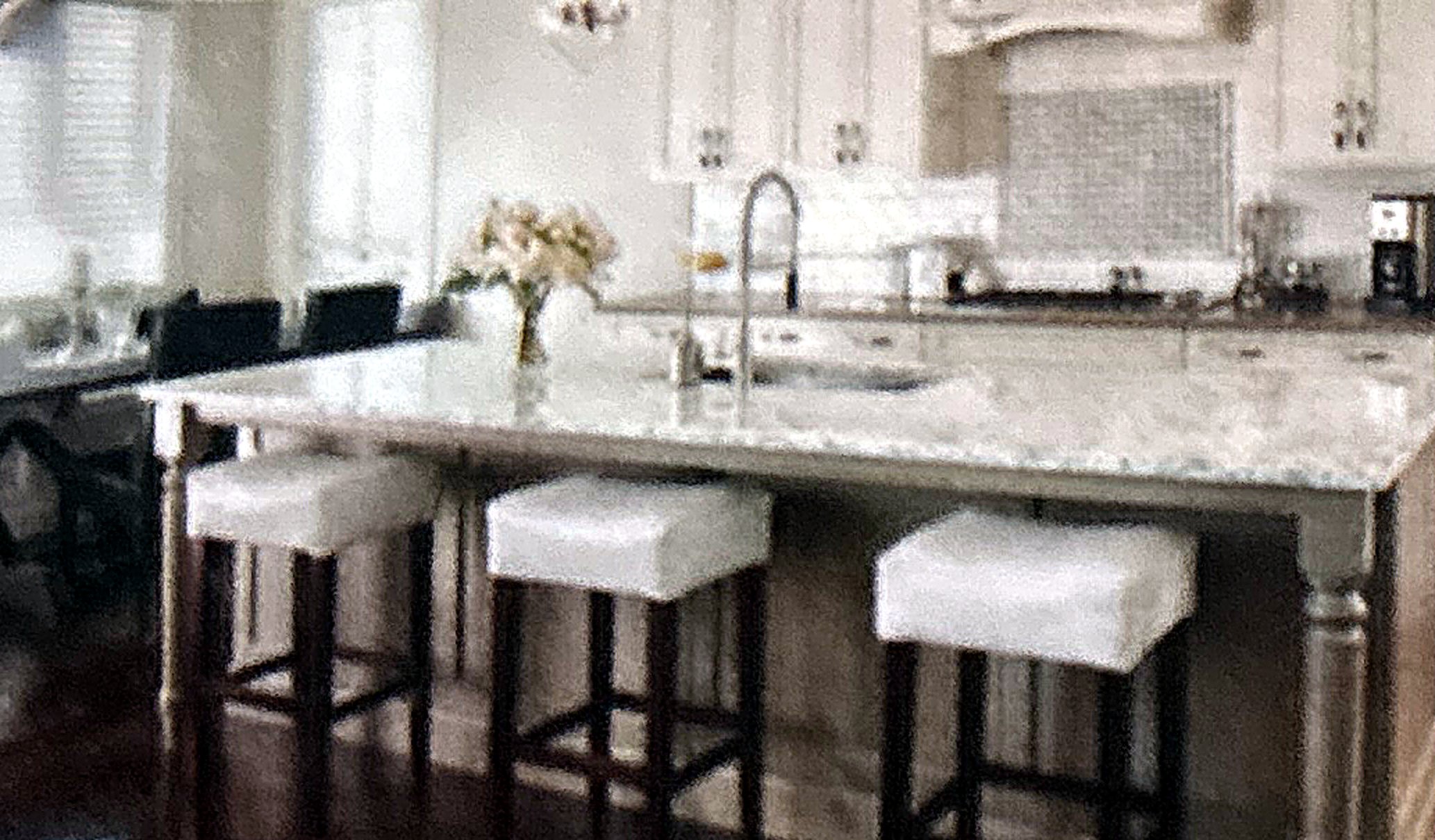 Remodeled white kitchen with marble island